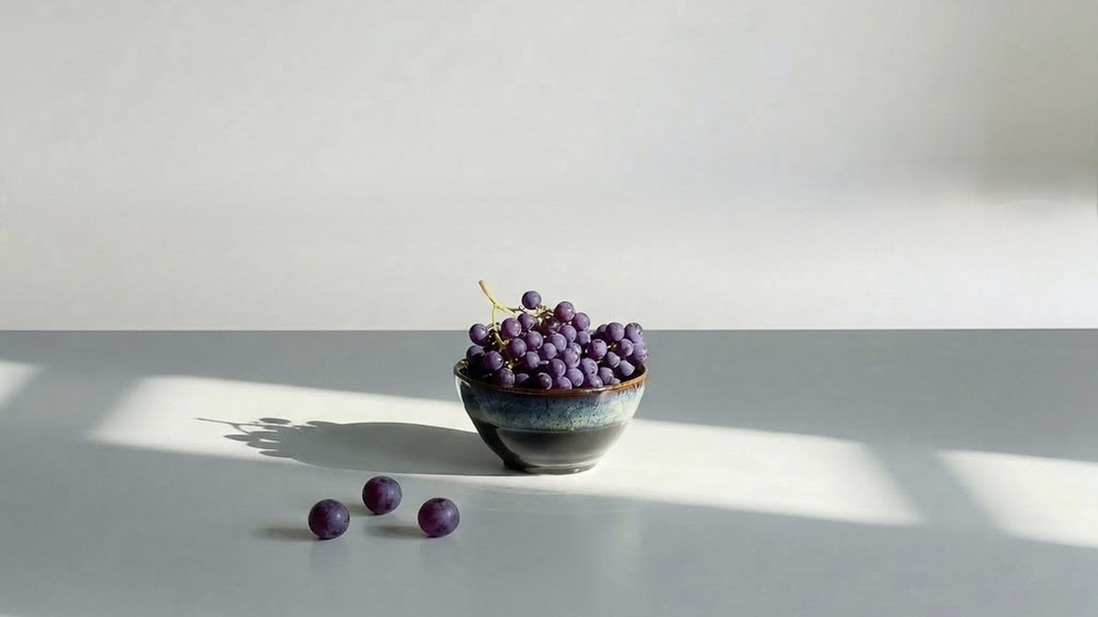 Stoneware bowl of grapes in soft daylight