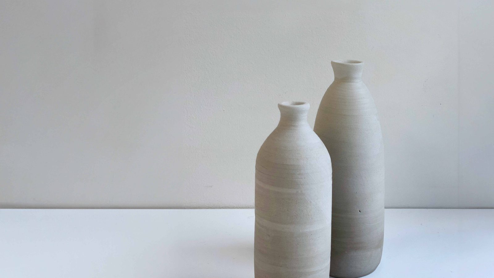 A pair of hand-thrown stoneware bottle vases